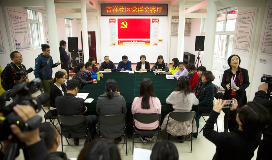 Journalists take photos of a meeting of a residential community during a media tour highlighting the Communist Party's efforts at the grassroots level in Beijing, Saturday, Oct. 14, 2017. (AP)