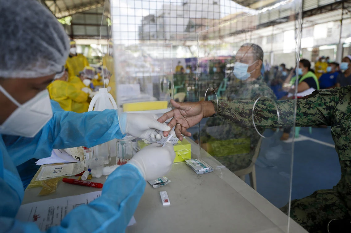 A health worker collects blood samples from police officers as they conduct mass testing for coronavirus in Manila, Philippines on Friday, May 8, 2020. (AP)