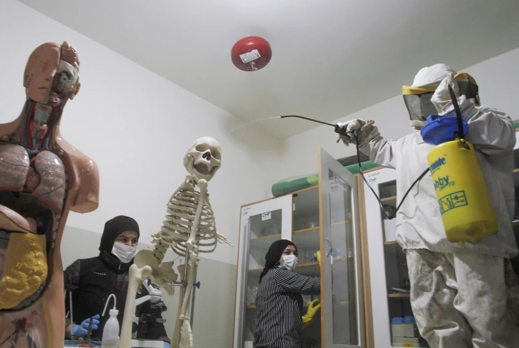 Lebanese workers spray disinfectant in classrooms and halls of a school in Rmeileh, south of Beirut, in this March 2, 2020 photo. (AFP)