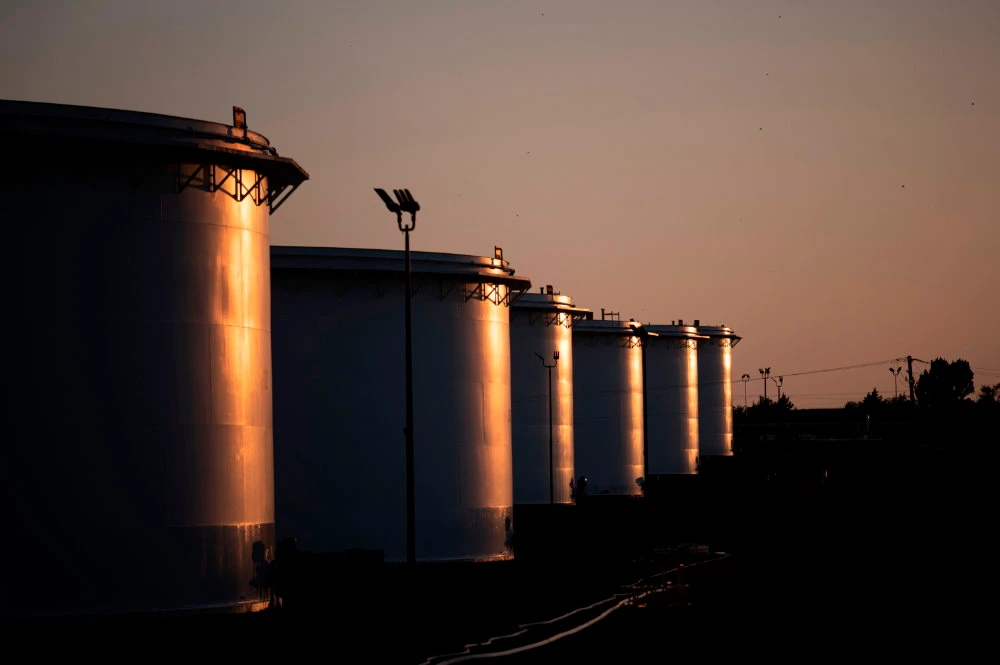 The sun sets behind a crude oil storage facility on May 4, 2020 in Cushing, Oklahoma. (AFP / Johannes Eisele)