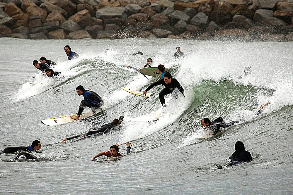 People surf in Barcelona, Spain, which reopened beaches for sporting activities after lockdown measures imposed due to coronavirus, were relaxed. (● Tourism, travel, hospitality business hit the hardest by virus. ● EU to unveil plan on Wednesday for gradual reopening. ● Brussels eyes state guarantees for canceled travel.AP)