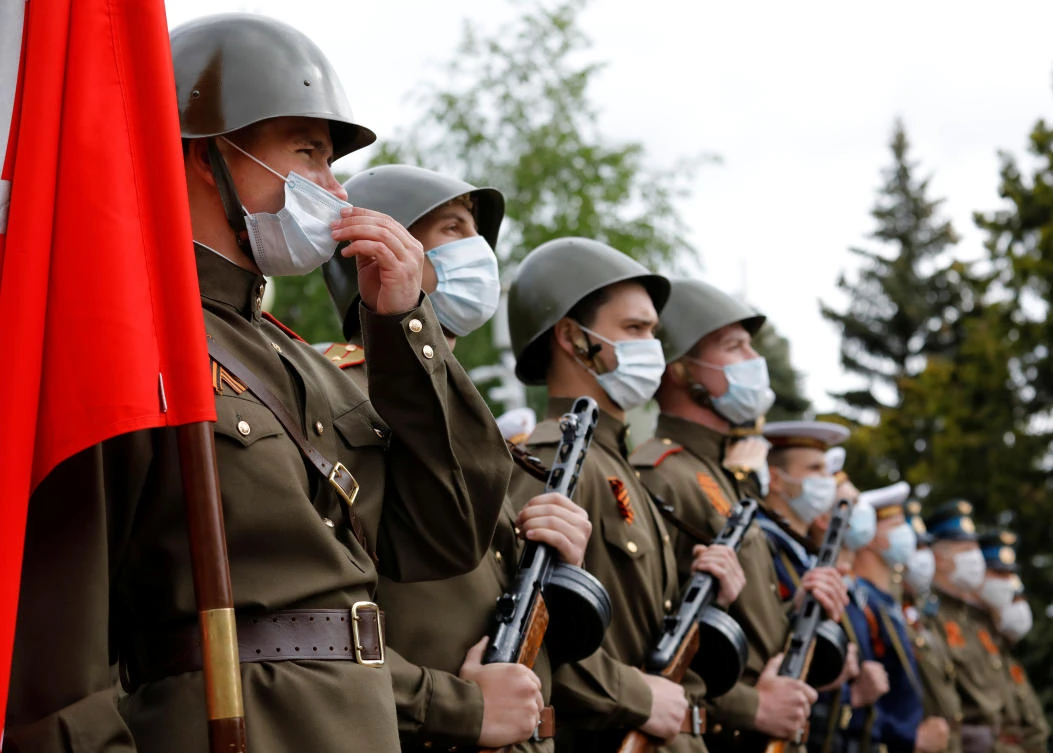 People wear protective face masks and Soviet-era military uniform as they line up during the celebrations of Victory Day in Stavropol, Russia on May 9, 2020. (Reuters)