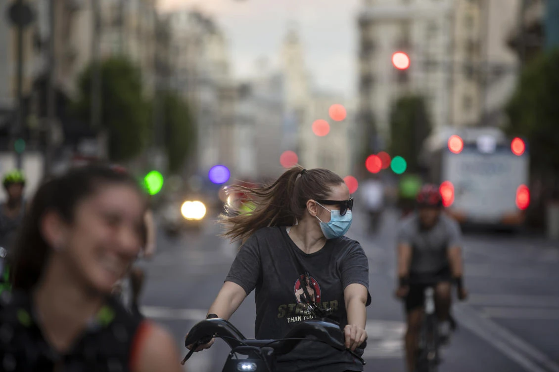 People wearing face masks ride bicycles at Gran Via in Madrid, Spain on Friday, May 8, 2020. (AP)