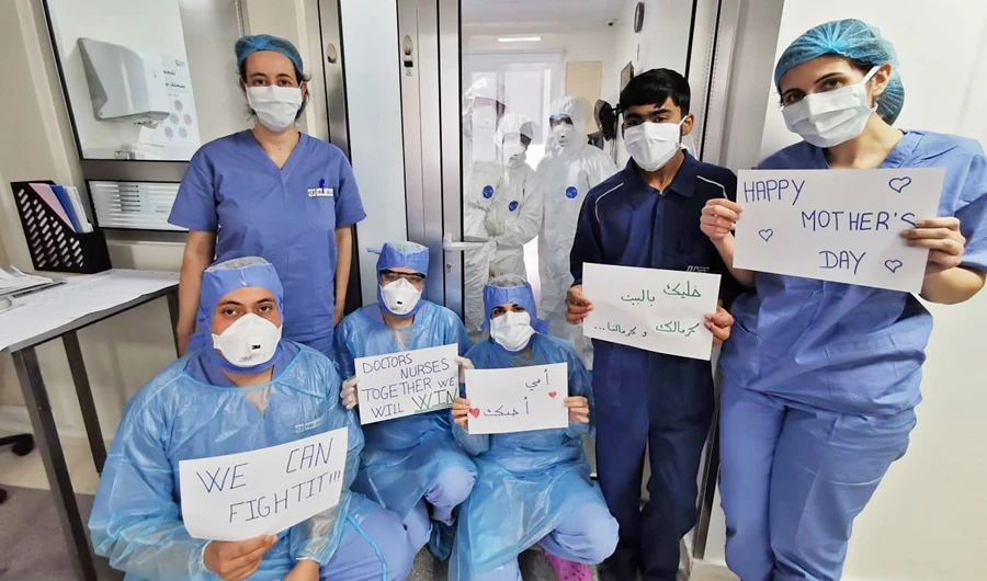 Medical staff at a hospital in Beirut’s eastern suburbs holding ‘Mother’s Day’ and other messages during a break in the coronavirus disease (COVID-19) section of the health facility. (AFP)