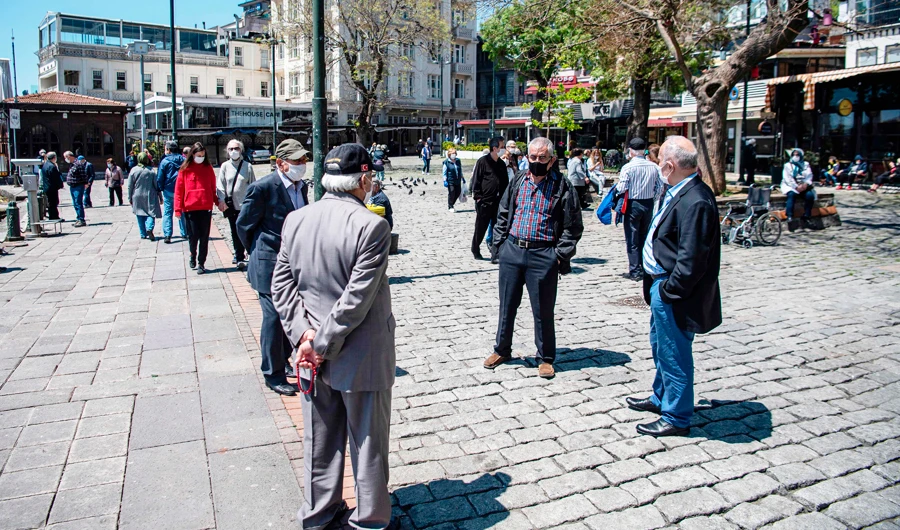Elderly people wear protective face masks as they chat at the recommended social distance at the seaside on May 10, 2020, at Ortakoy in Istanbul, after a month and a half of lockdown restrictions aimed at stemming the spread of the novel coronavirus, COVID-19. (AFP)