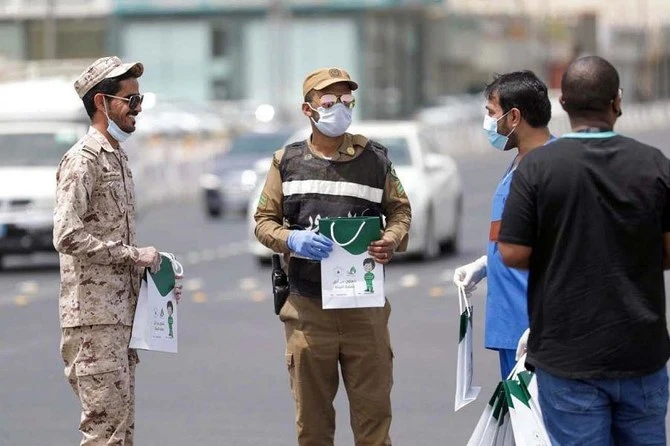 Police standing with Saudi national to guide them on coronavirus in Saudi Arabia. (SPA)
