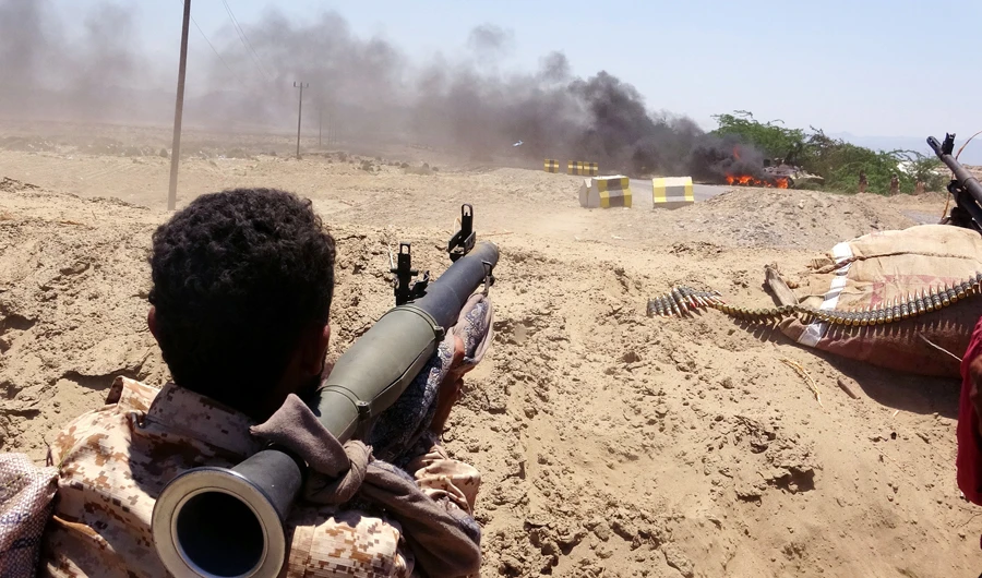 A fighter from of the Southern Transitional Council (STC) watches as a military vehicle, belonging to Saudi-backed government forces, burns during clashes in the Sheikh Salim area in the southern Abyan province on May 11, 2020. (AFP)
