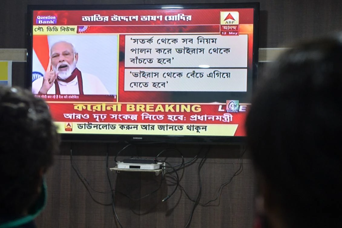 People watch Indian Prime Minister Narendra Modi’s address to the nation on a television, during the government-imposed nationwide lockdown, in Siliguri, May 12, 2020. (AFP)