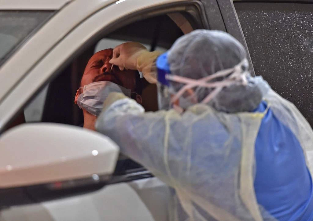 Health workers perform nose swab tests during a drive through coronavirus test campaign held in Diriyah hospital in the Saudi capital Riyadh on May 7, 2020 amid the COVID-19 pandemic. (AFP)