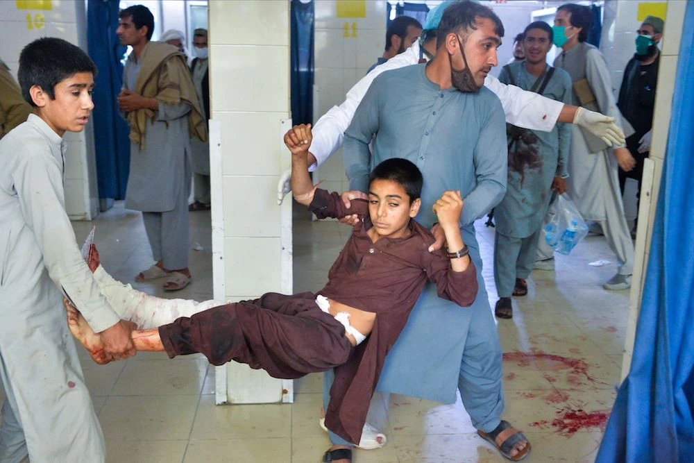 Volunteers carry an injured boy in a hospital following a suicide attack at a funeral of a local police commander in Nangarhar. (AFP)