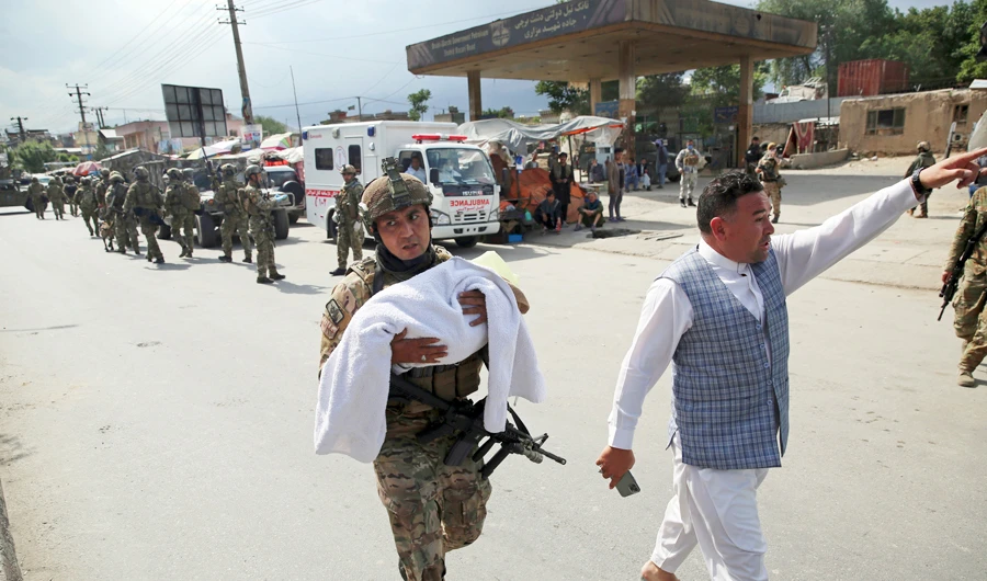 An Afghan security officer carries a baby after gunmen attacked a maternity hospital in Kabul on Tuesday. Gunmen stormed the hospital in the western part of Kabul. (AP)