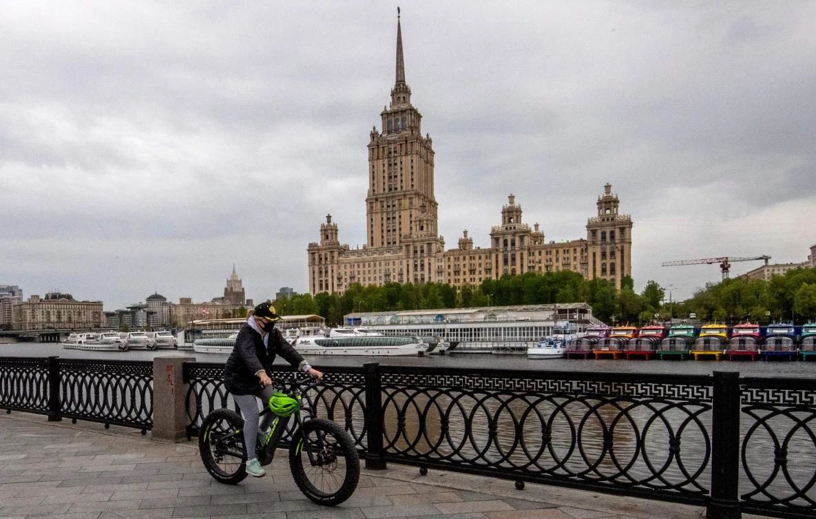 Russia reported 10,028 new confirmed cases of the novel coronavirus, pushing its nationwide tally to 242,271. Above, a woman wears a protective face mask as she rides a bike along the Moskva river embankment in central Moscow on May 10, 2020. (AFP)