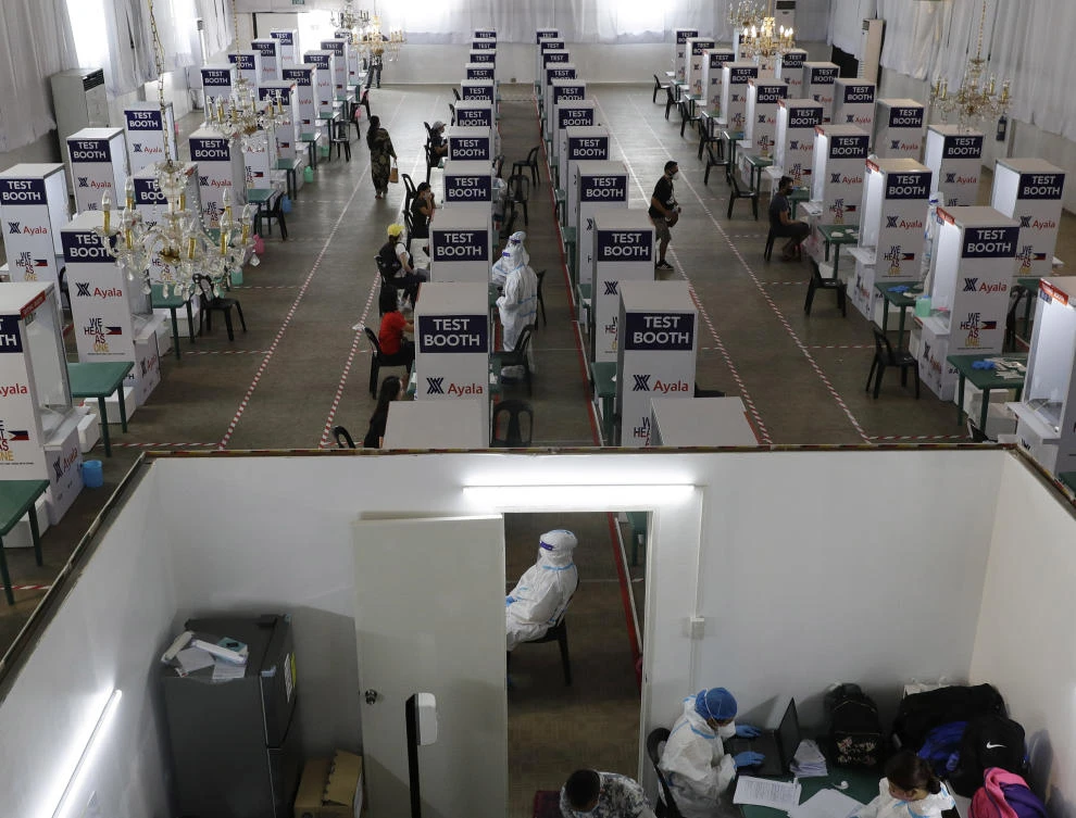 Above, health workers at a coronavirus testing center in Manila, Philippines on May 11, 2020. Several sports and events venues have been converted as quarantine facilities or testing centers as the country tries to cope with the ongoing pandemic. (AP)