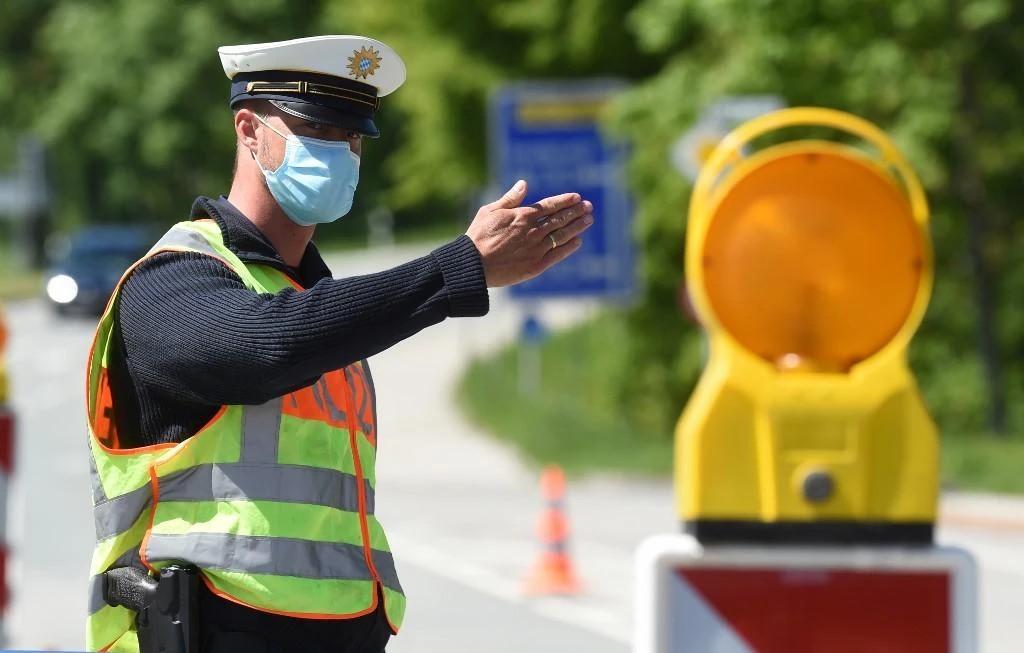 A German police officer wears a protective mask during a car control at the border crossing between Austria and Germany on May 7, 2020. (AFP)