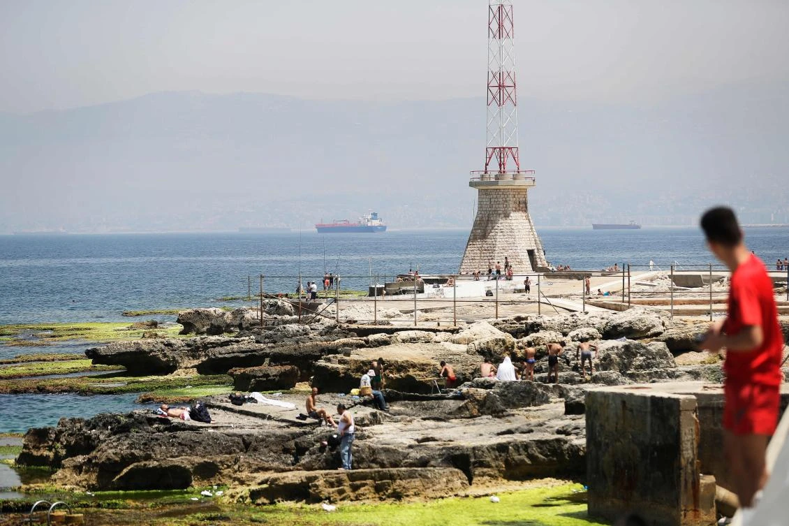 Lebanese gather by the Mediterranean Sea near Beirut's seaside corniche on May, 13, 2020. Lebanon's cabinet has announced yesterday a four-day nationwide lockdown from wednesday evening after a spike in COVID-19 cases. (AFP)