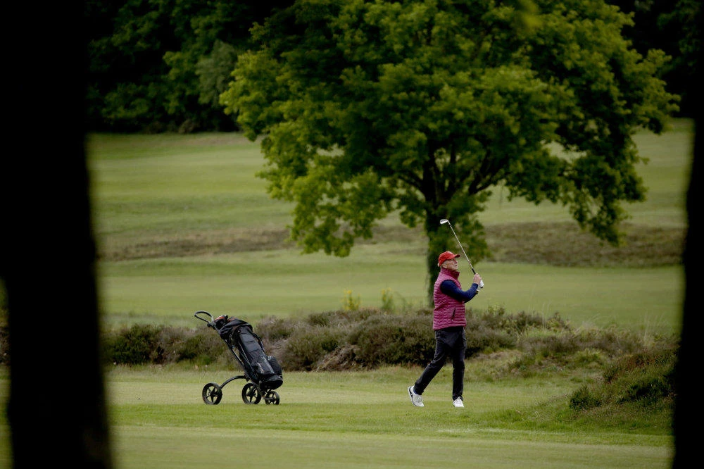 A golfer hits a shot after Sunningdale Golf Club reopened this morning as part of the British government relaxing the coronavirus lockdown measures, in Sunningdale, England, on May 13, 2020. (AP Photo/Matt Dunham)
