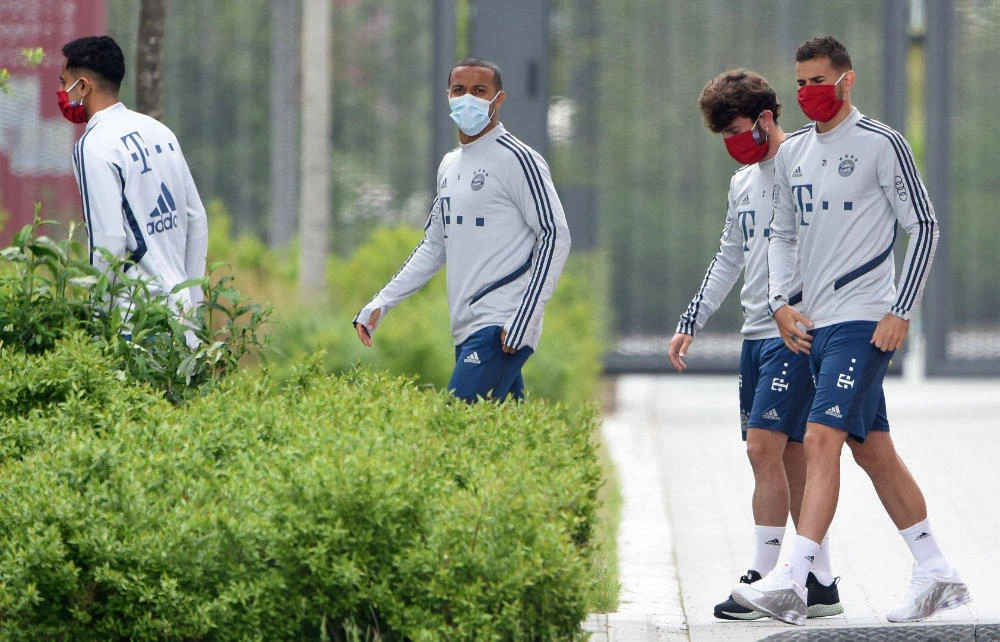 From left: French midfielder Corentin Tolisso, Spanish midfielder Thiago Alcantara, Spanish defender Alvaro Odriozola and French defender Lucas Hernandez arrive for a training session of the German first division Bundesliga football club FC Bayern Munich on May 13, 2020 at the Bayern's campus in Munich, Germany. (AFP / Christof Stache)