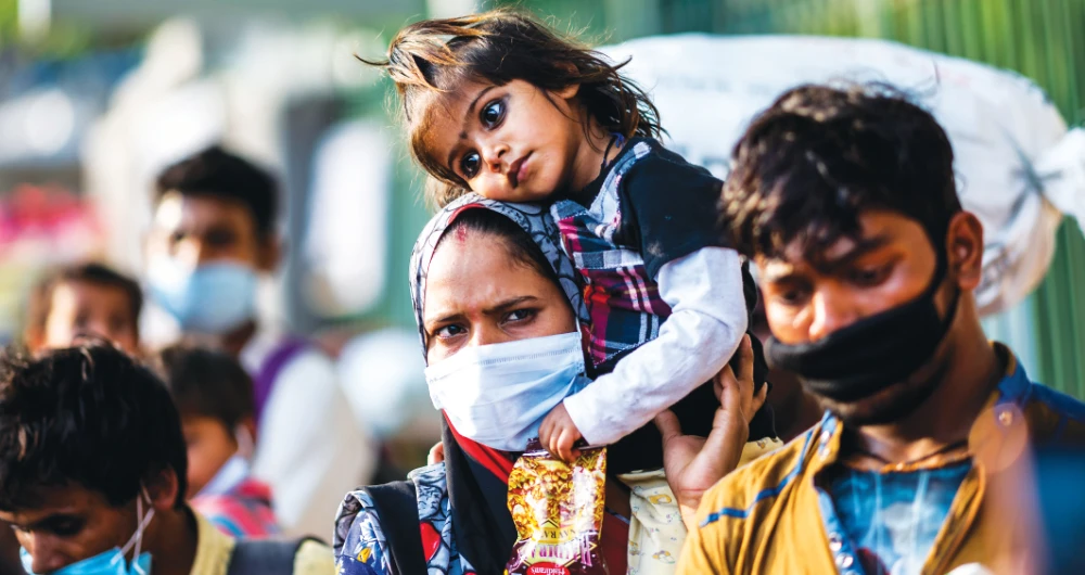 A migrant worker mother carries her daughter on her shoulder during a nationwide lockdown imposed as a preventive measure against the spread of the coronavirus in New Delhi. (AFP)