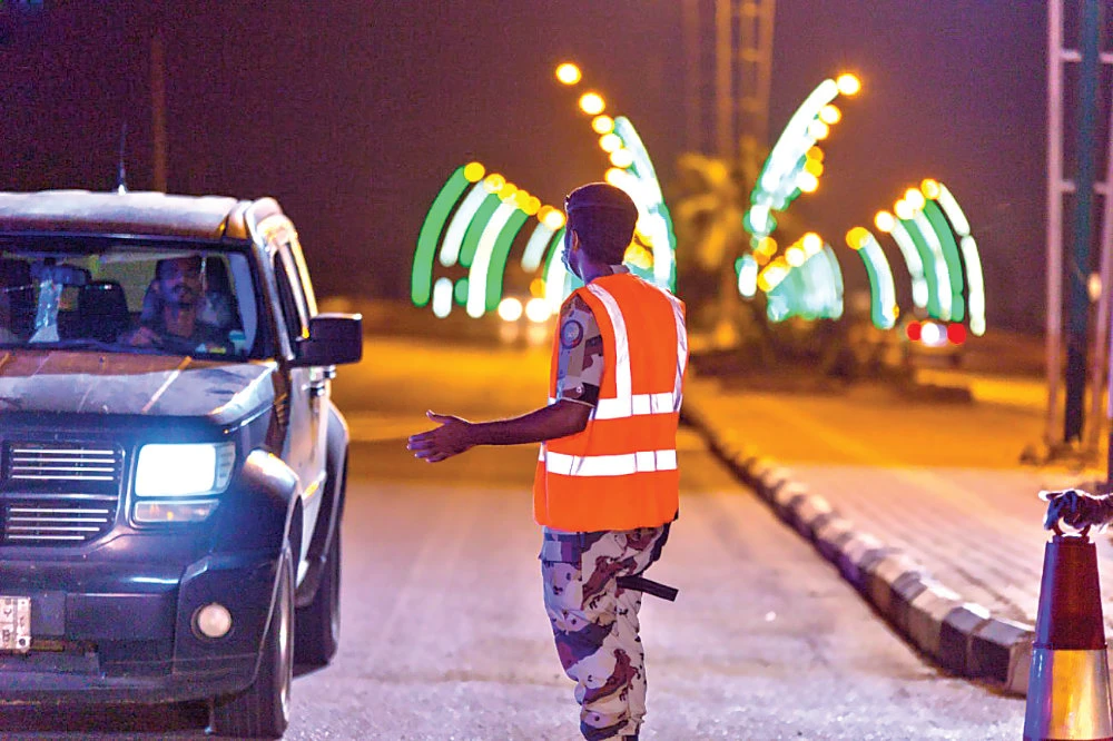 Security official enforcing the curfew to limit the spread of coronavirus check a motorist in the Baish governorate of Jazan region on Wednesday. (SPA)