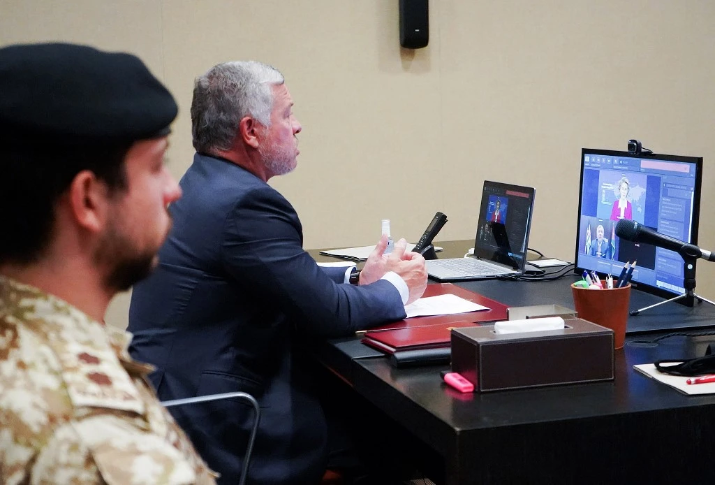 Jordanian King Abdullah II, right, and son Crown Prince Hussein, left, attend a videoconference on coronavirus global response international pledging event in this handout picture released by the Jordanian Royal Palace on May 4, 2020. (Jordanian Royal Palace/AFP)