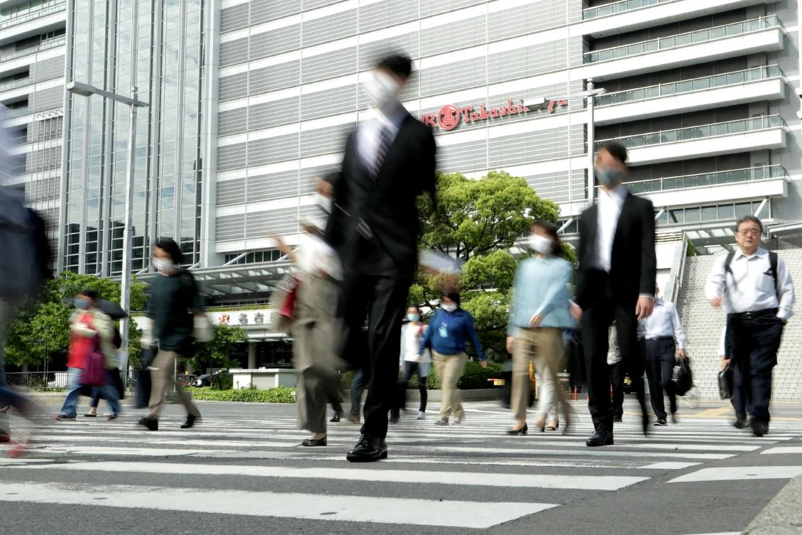 Large parts of Japan marked the first day out of a state of emergency on Friday while major cities remained under coronavirus restrictions. Above, people commute to work from Nagoya train station in Nagoya, Aichi prefecture on May 15, 2020. (Jiji Press/AFP)