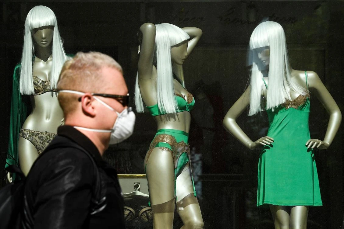 A pedestrian wearing a protective facemask walks past a closed shop in Moscow on May 11, 2020, during a strict lockdown in Russia to stop the spread of coronavirus. (AFP)