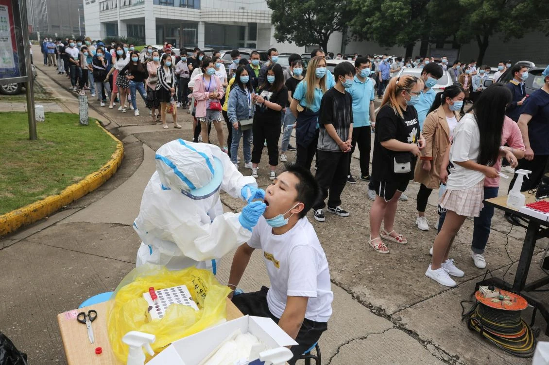 A medical worker takes a swab sample from a staff member from the AOC computer monitor factory to be tested for the COVID-19 coronavirus in Wuhan in China's central Hubei province on May 15, 2020. (AFP)