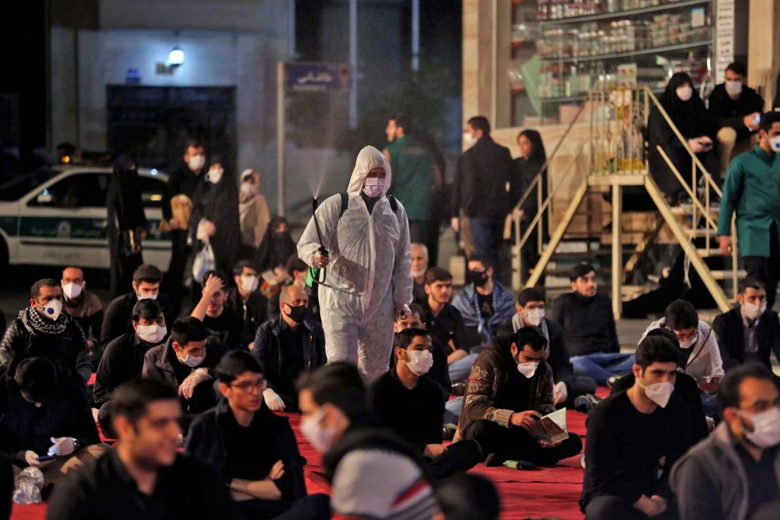Iranians, some wearing face masks against the Covid-19 coronavirus, attend Laylat Al-Qadr prayers, one of the holiest nights during Ramadan, outside a mosque in the Tehran, on May 13, 2020. (AFP)