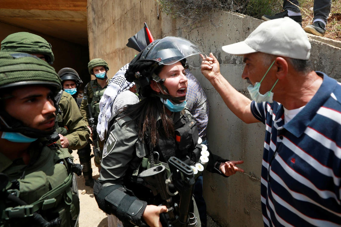 A Palestinian man argues with an Israeli border policewoman during a protest marking the 72nd anniversary of Nakba and against Israeli plan to annex parts of the occupied West Bank, in the village of Sawiya near Nablus May 15, 2020. (Reuters)