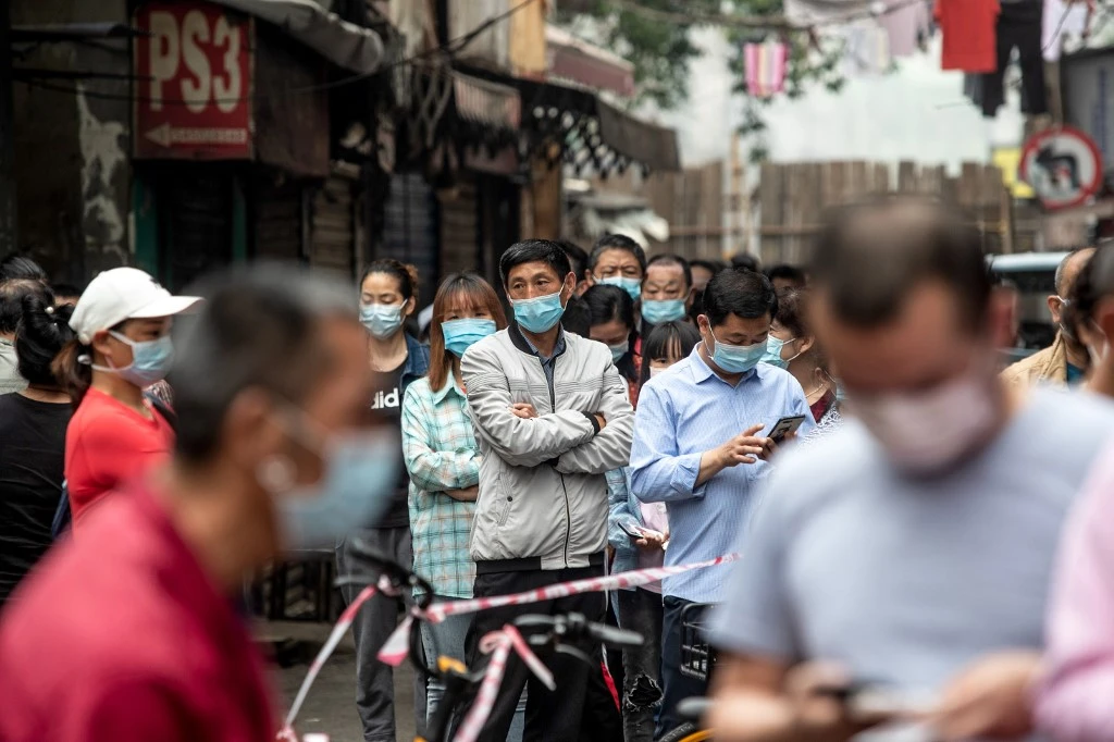 Residents wait in line to provide swab samples to be tested for coronavirus in Wuhan on May 15, 2020. (AFP)