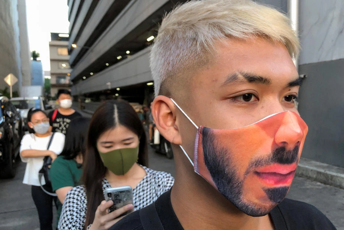 The Thai government has eased isolation measures and reopened businesses. Above, a man wearing a protective mask waits in a line for temperature screening before entering the Ratchada Railway Night Market in Bangkok on May 15, 2020. (Reuters)