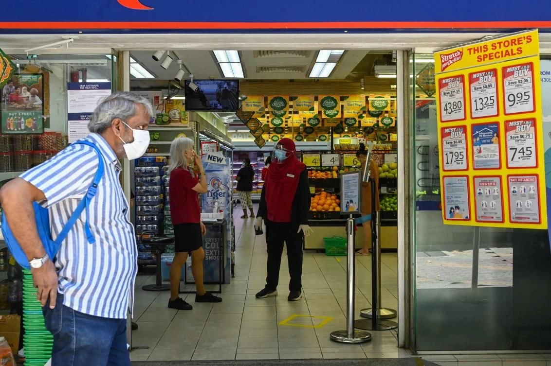 Above, employees wear face masks as a preventive measure against the spread of coronavirus in Singapore on May 14, 2020. Singapore said the vast majority of the newly infected people are migrant workers living in dormitories. (AFP)