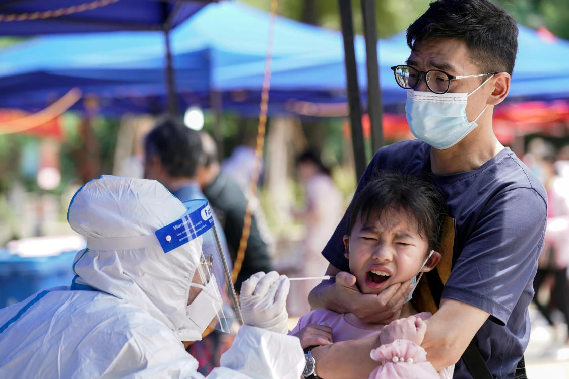 A child reacts while undergoing nucleic acid testing in Wuhan, the Chinese city hit hardest by the coronavirus outbreak on May 16, 2020. (Reuters)