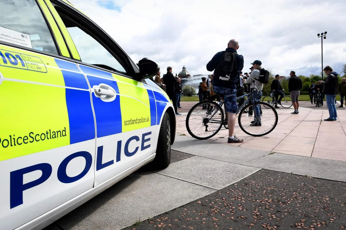 Police monitor as people attend an anti-lockdown gathering on Glasgow Green in the centre of Glasgow on May 16, 2020, following an easing of lockdown rules in England during the novel coronavirus COVID-19 pandemic. (AFP)