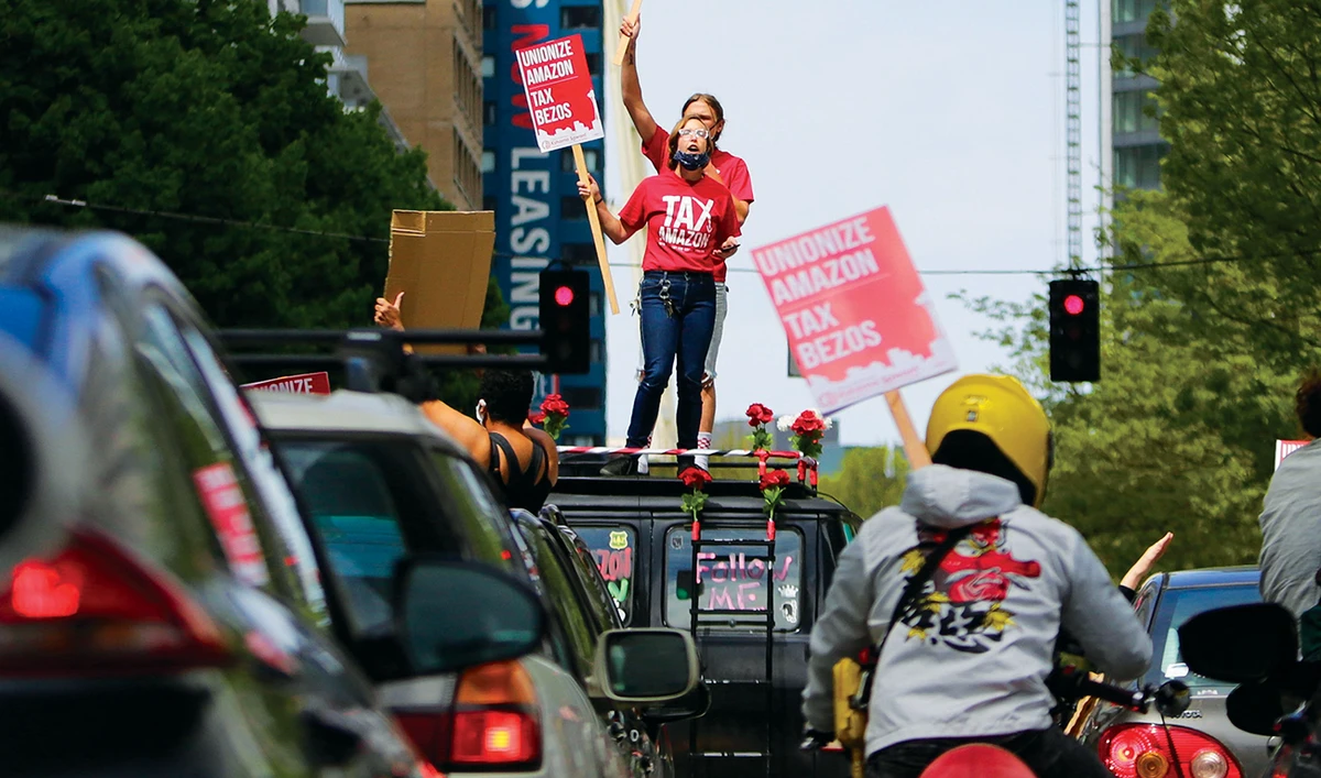 Protesters stand on their car and block traffic during a demonstration at the Amazon Spheres in Seattle. (AFP)