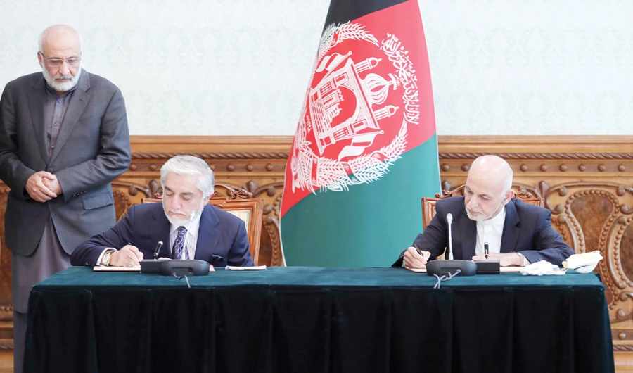 Afghan President Ashraf Ghani, right, and chief rival Abdullah Abdullah sign a power-sharing agreement at the presidential palace in Kabul on Sunday. (AP)
