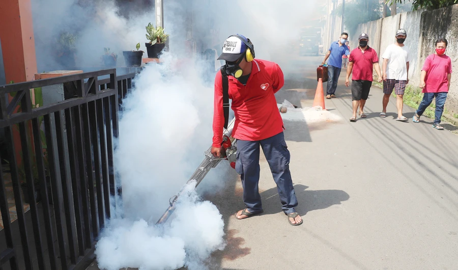 A worker fumigates a neighborhood in an effort to control the spread of dengue fever, amid the new coronavirus outbreak in Jakarta. (AP)