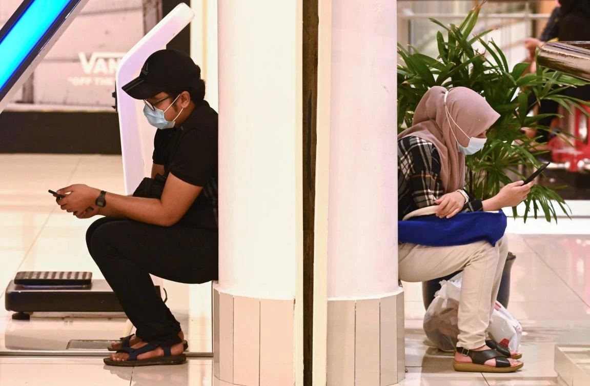 Shoppers wearing face masks relax at a mall as businesses reopened in Penang on May 17, 2020, with Malaysia relaxing its partial lockdown to contain the spread of the COVID-19 coronavirus. (AFP)