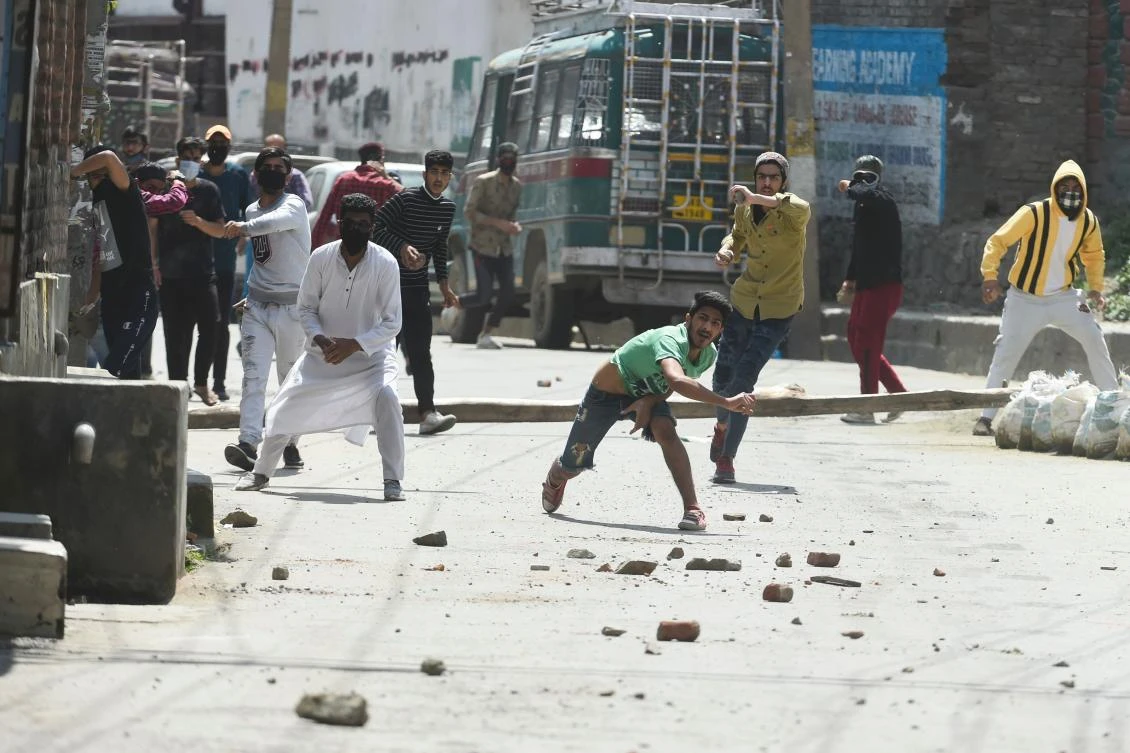 Protesters throw stones at Indian government forces following a gunbattle between militants and government forces in Srinagar on May 19, 2020. (AFP)