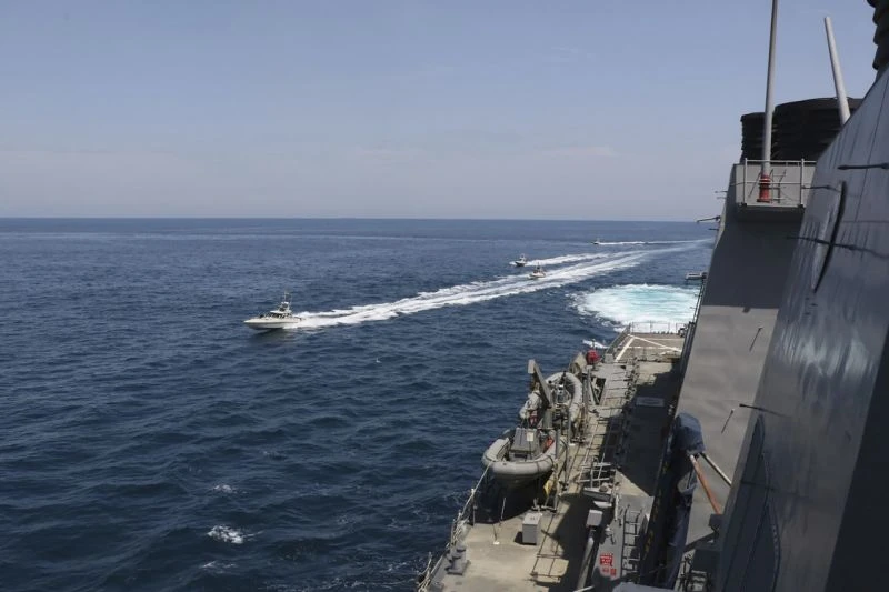 In this Wednesday, April 15, 2020, photo made available by U.S. Navy, Iranian Revolutionary Guard vessels sail close to U.S. military ships in the Arabian Gulf. (AP/Via US Navy)