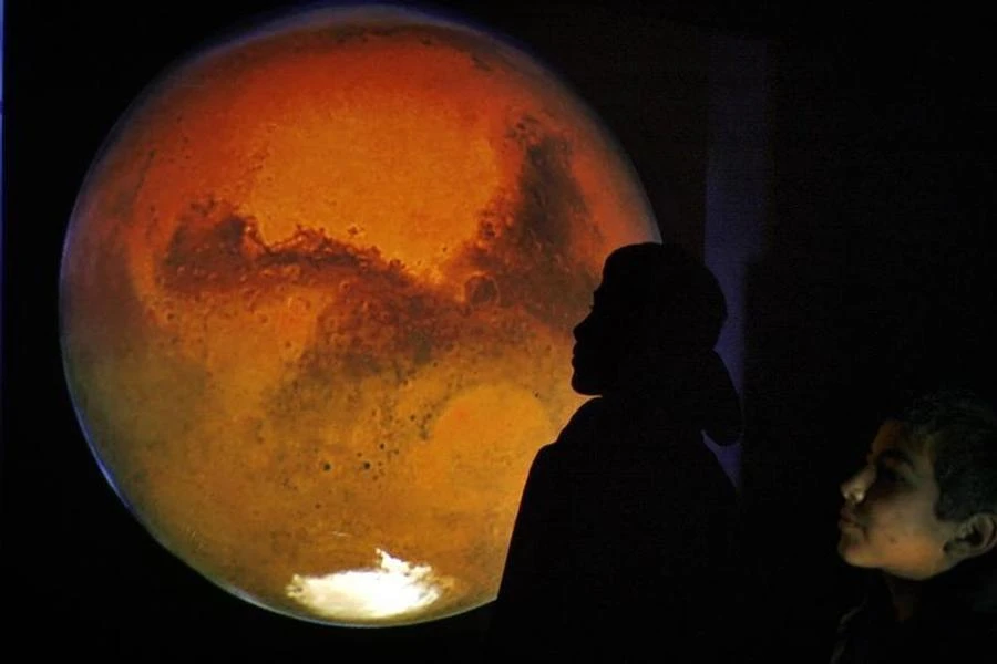 A Jordanian boy poses with an image of Mars projected on a wall during a gathering to watch the red planet in Amman's sky January 28, 2010. (Reuters)