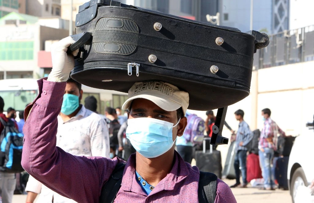 Above, an undocumented expatriate queues outside a Kuwait school that was turned into a center to receive residency violators wishing to avail of the amnesty program on April 16, 2020. (AFP)