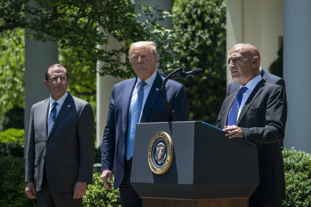 President Donald Trump listens as Dr. Moncef Slaoui speaks about coronavirus vaccine development in the Rose Garden of the White House on May 15, 2020. (AFP)