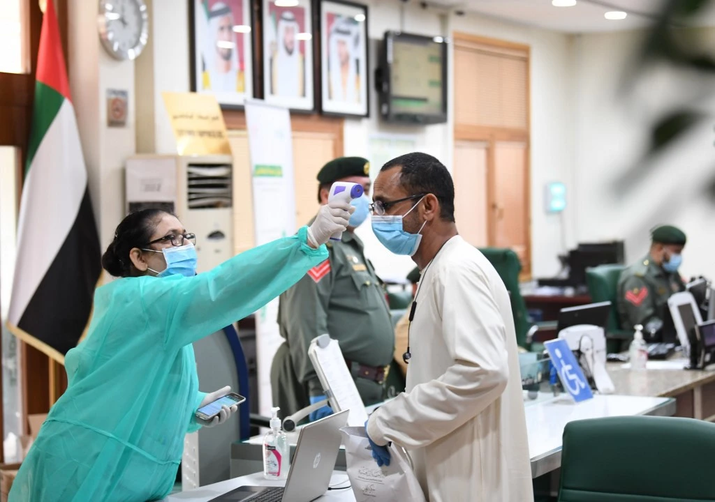 A resident has his body temperature reading taken upon arriving at the Naif police station in Dubai for coronavirus screening on April 15, 2020. (AFP file photo)