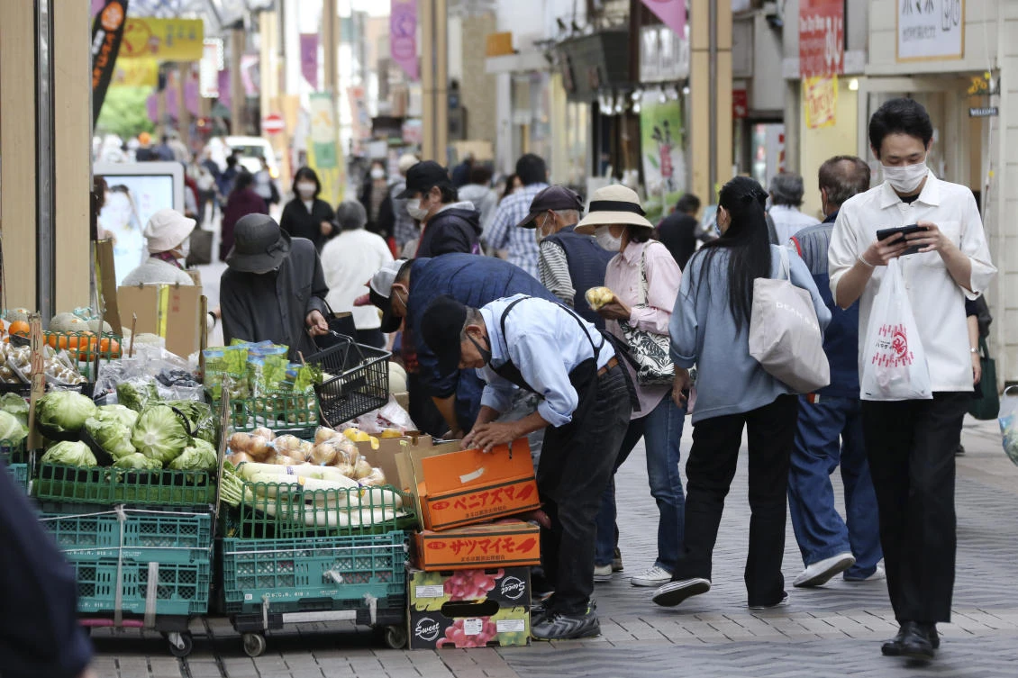 People wearing face masks shop at a mall in Yokohama near Tokyo on May 19, 2020. Japan ended of the state of emergency for most regions of the country, but restrictions are being kept in place in Tokyo and seven other high-risk areas. (AP)