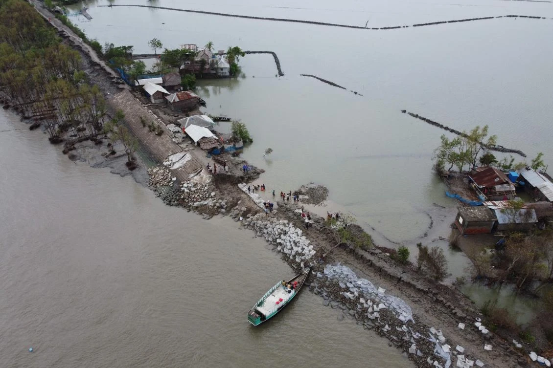 An aerial view shows volunteers and residents working to fix a damaged dam following the landfall of cyclone Amphan in Burigoalini on May 21, 2020. (AFP)