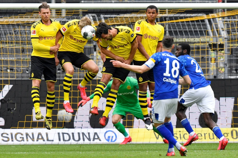 Schalke’s Daniel Caligiuri has his free kick blocked by Borussia Dortmund players during their Bundesliga match last Saturday. (Reuters)