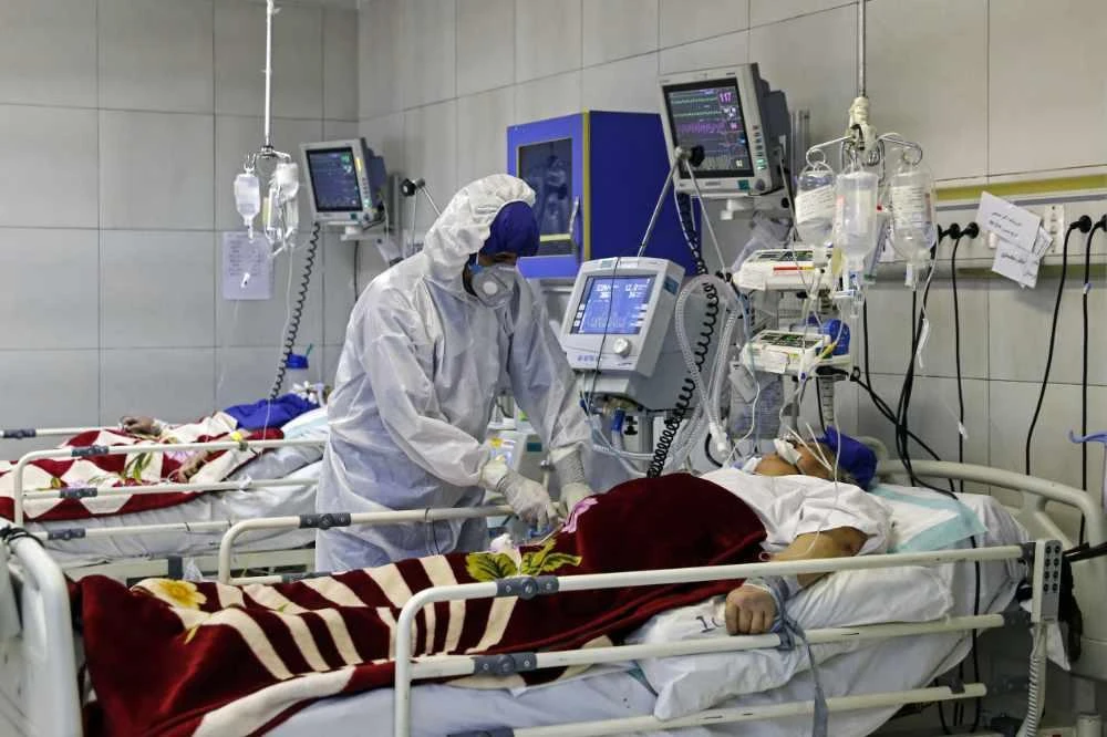 In this March 1, 2020 file photo, a medic treats a patient infected with coronavirus, at a hospital in Tehran. (Ali Shirband/Mizan News Agency via AP, File)