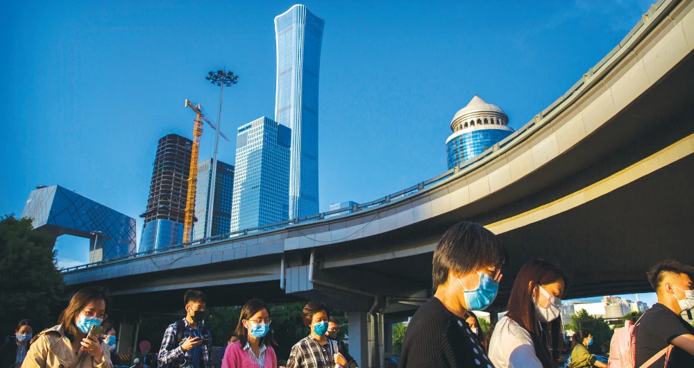 Chinese commuters walk to work wearing face masks in Beijing. (AP)