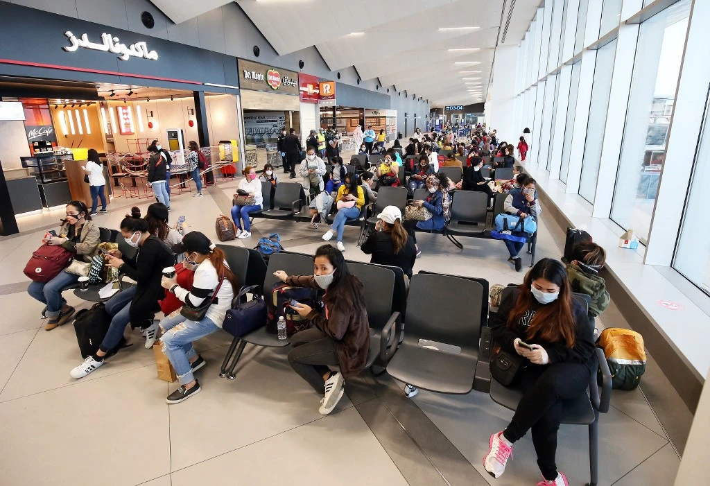 Filipinos who availed general amnesty granted by the Kuwaiti government wait for their flight home at the Kuwait International Airport on April 3, 2020. (AFP)